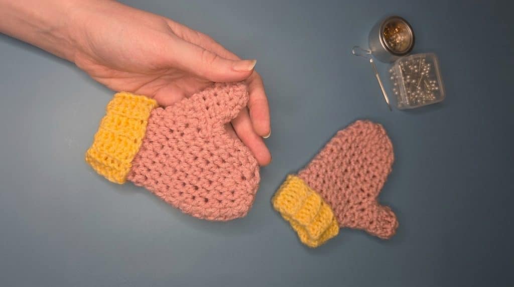 Yellow and pink crochet mittens made for a toddler before an ice storm
